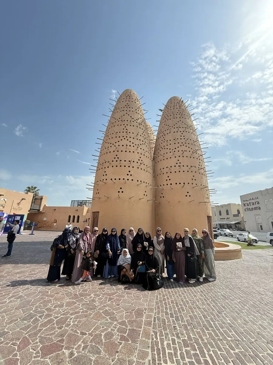Jamaah berfoto di depan menara merpati Katara, Doha