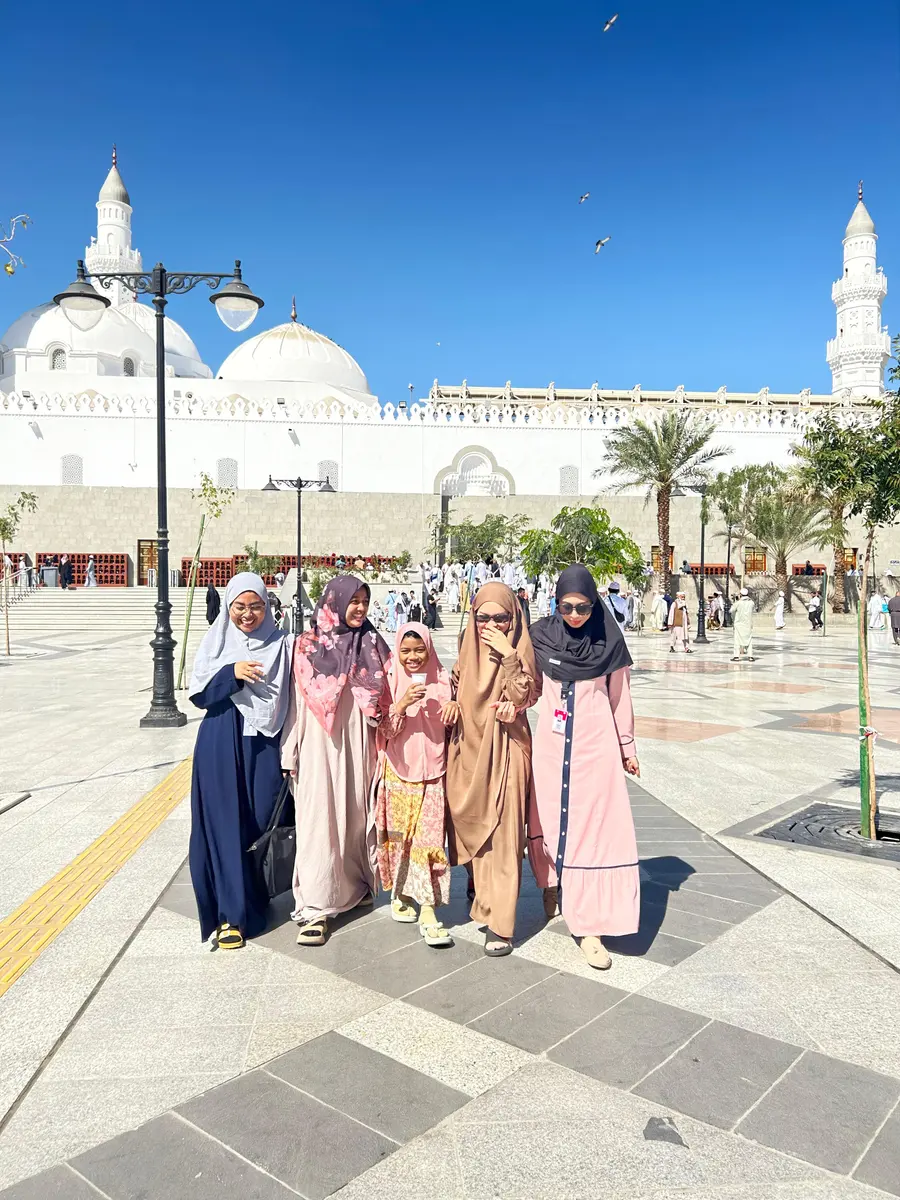 Keluarga jamaah tersenyum di depan Masjid Quba